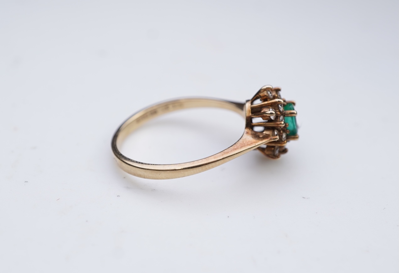 An emerald and diamond cluster ring